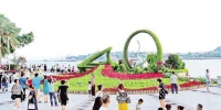 昨日，游客在轮渡音乐喷泉广场与绿雕“琴音鹭波”合影。记者 陈理杰 摄 - 新浪