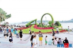 昨日，游客在轮渡音乐喷泉广场与绿雕“琴音鹭波”合影。记者 陈理杰 摄 - 新浪