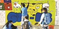 厦门大学学生在修复被游客涂鸦的墙面 - 新浪
