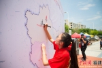 来自全国各地的学子，在印制有中国地图的太空架上进行火炬传递、签名。李南轩 摄 - 福建新闻