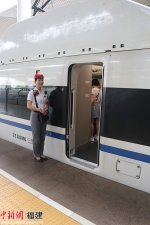 列车长陈俣蒙在车门外微笑迎客。吴林 摄 - 福建新闻