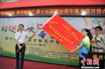 8月19日，福州市政协副主席林锋（左）为榕台青年夏令营授旗。　记者 张斌　摄 - 福建新闻