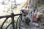 在悬崖游步道工程现场，工人正在进行护栏包浆作业。 - 新浪