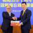 厦门银行董事长吴世群(右)代表厦门银行向富邦金控总经理韩蔚廷发放股权证。　供图 摄 - 福建新闻