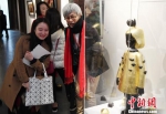 一名女性观众与日本艺术家伊能一三(图中)在其参展作品《和平之车(女孩)》前合影留念。　记者刘可耕 摄 - 福建新闻