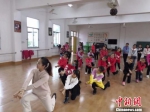 图为50号志愿者洪巧明带领三明市清流县长校中心小学孩子们跳舞。　吕明 摄 - 福建新闻