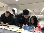 　福州机场出入境边防检查站边检警察正在福州机场口岸帮助旅客填写出境卡。　李晓烺 摄 - 福建新闻