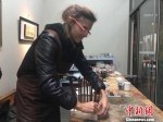 在工作台前，多米尼克·亨伯特正在用木坯筷子学习漆艺装饰。　叶秋云 摄 - 福建新闻