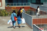 7行走在福州大学晋江科教园内的学生，他们手里拎着学术研究所需要的材料。林坚 摄 - 福建新闻