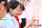 活动现场，家长代表与学生们在“铁路文明好习惯，晋七护路在行动”横幅上签名。林坚 摄 - 福建新闻