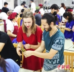 留学生对中国包粽子民俗饶有兴趣。供图 摄 - 福建新闻