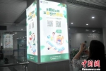 图为旅客在机场扫描二维码体验AR导览。吕明 摄 - 福建新闻