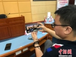 工作人员展示用5G手机观看庭审直播。　黄咏绸 摄 - 福建新闻