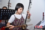 7岁的张泷月正认真练习二胡。陈龙山 摄 - 福建新闻