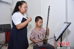 11岁的王若城练习北管多年，已经掌握了唱腔和弦乐演奏。陈龙山 摄 - 福建新闻