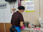 在食堂的分餐处，杨师傅已经开始忙碌起来，给需要送餐上门的老人备餐。　叶秋云 摄 - 福建新闻