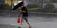 8月25日，受台风“白鹿”影响，厦门遭遇大风暴雨。图为厦门市民在大雨中出行。 中新社记者 张斌 摄 - 福建新闻