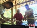 　　图为黄春财与儿子、孙子共同演示木拱廊桥搭建。　叶茂 摄 - 福建新闻