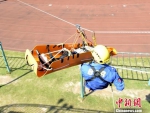 9月18日，福建省泉州市举行第22次防空警报试鸣暨人口疏散演练。图为参演人员利用滑梯运送伤员。　彭勇 摄 - 福建新闻