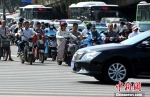 10月10日，福州街头，民众骑着电动自行车出行。中新社记者 张斌 摄 - 福建新闻