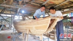 图为连家渔船复建过程中郑文祥(右)向其孙子郑煜元传授建造技巧。　吕雷 摄 - 福建新闻