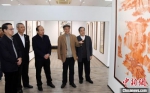 著名艺术家沈岩先生(右二)向来宾介绍在馆内展出、由他本人创作的80多幅书画作品。　记者刘可耕 摄 - 福建新闻