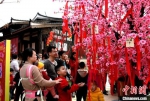 游客纷纷在许愿树前求“桃花运”。　王东明 摄 - 福建新闻