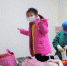 图为在周宁县健康观察点，医务人员为解除医学观察的两名小孩收拾衣物。　黄起青 摄 - 福建新闻