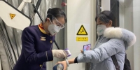 乘务员为旅客检测体温。福州航空供图 - 福建新闻