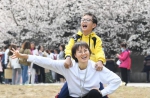 3月13日，广东援鄂医疗队成员梁仕凤带着孩子来到武汉大学赏樱游玩。 - 新浪