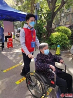 晋安区象园街道乐西社区志愿者为出行不便的老人推轮椅 东南网记者 陈楠 摄 - 福建新闻