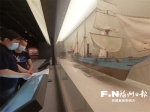 杨帆（后）和陈悦拿着型线图比对万年清船模。记者 欧阳进权 摄 - 福建新闻