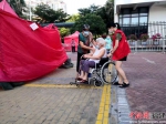 志愿者帮助行动不便的老人。陈向辉 摄 - 福建新闻