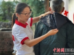 在永泰开展活动时，陈霞为老人对比新衣服是否合身。受访者 供图 - 福建新闻